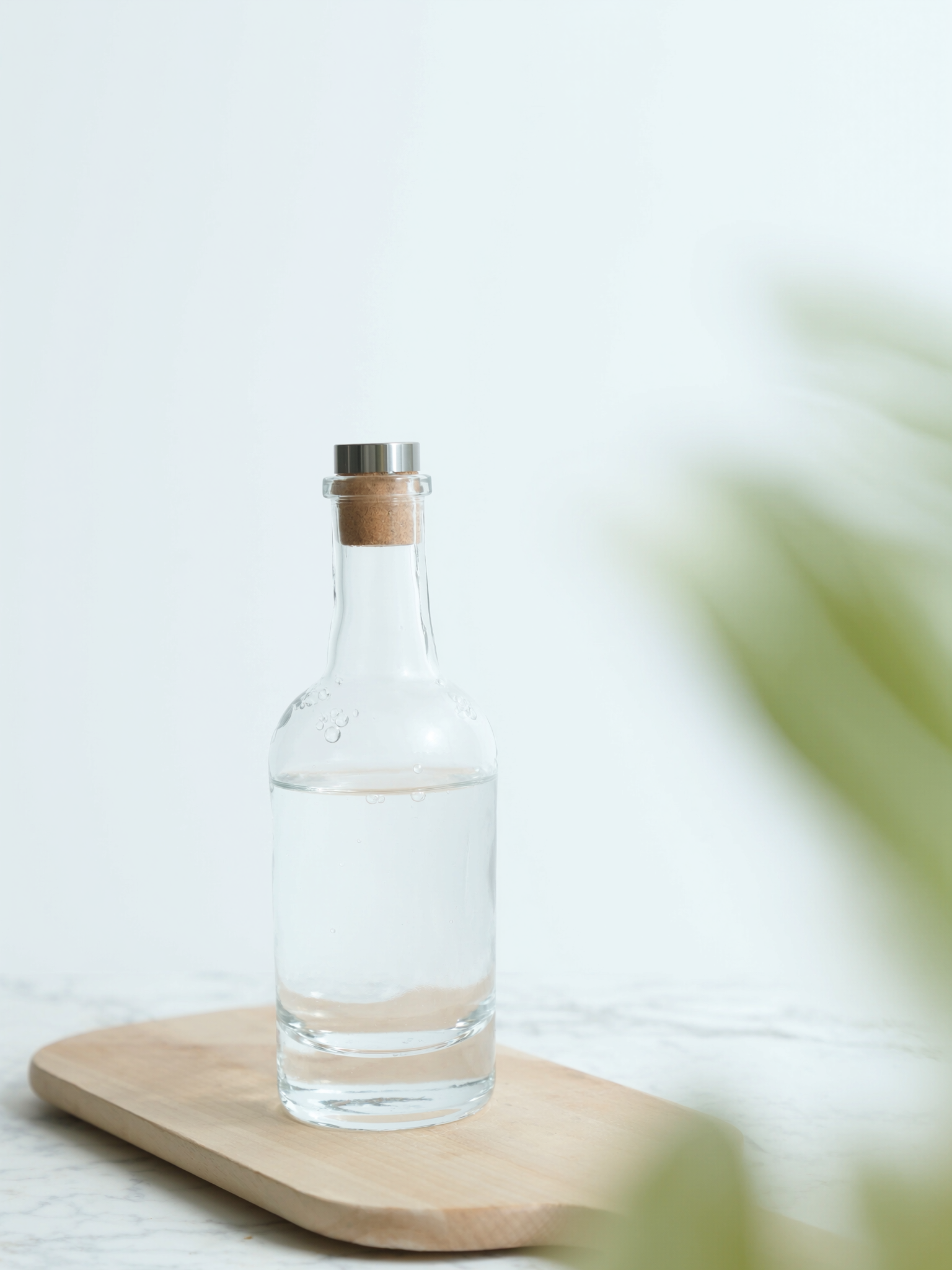 Botella de agua de cristal sobre una superficie natural